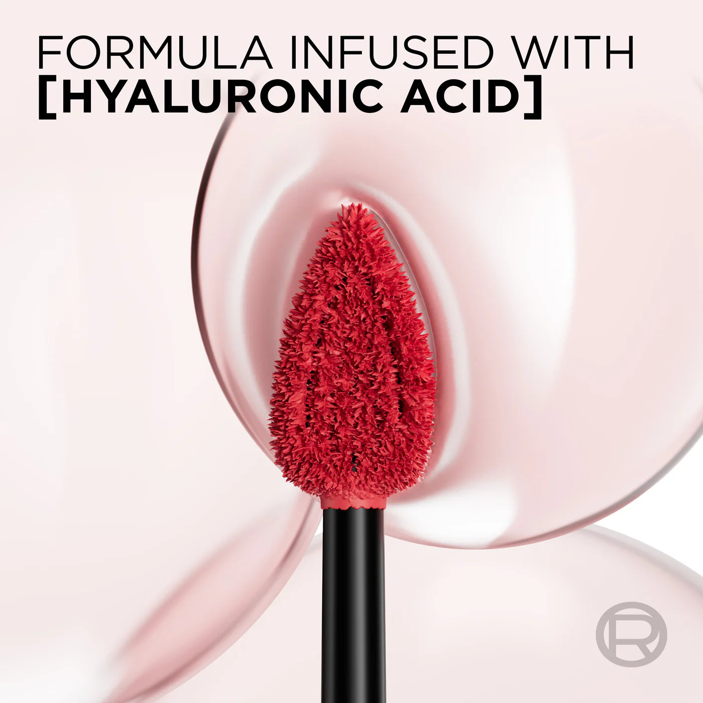 Red makeup brush with hyaluronic acid text on a pink background