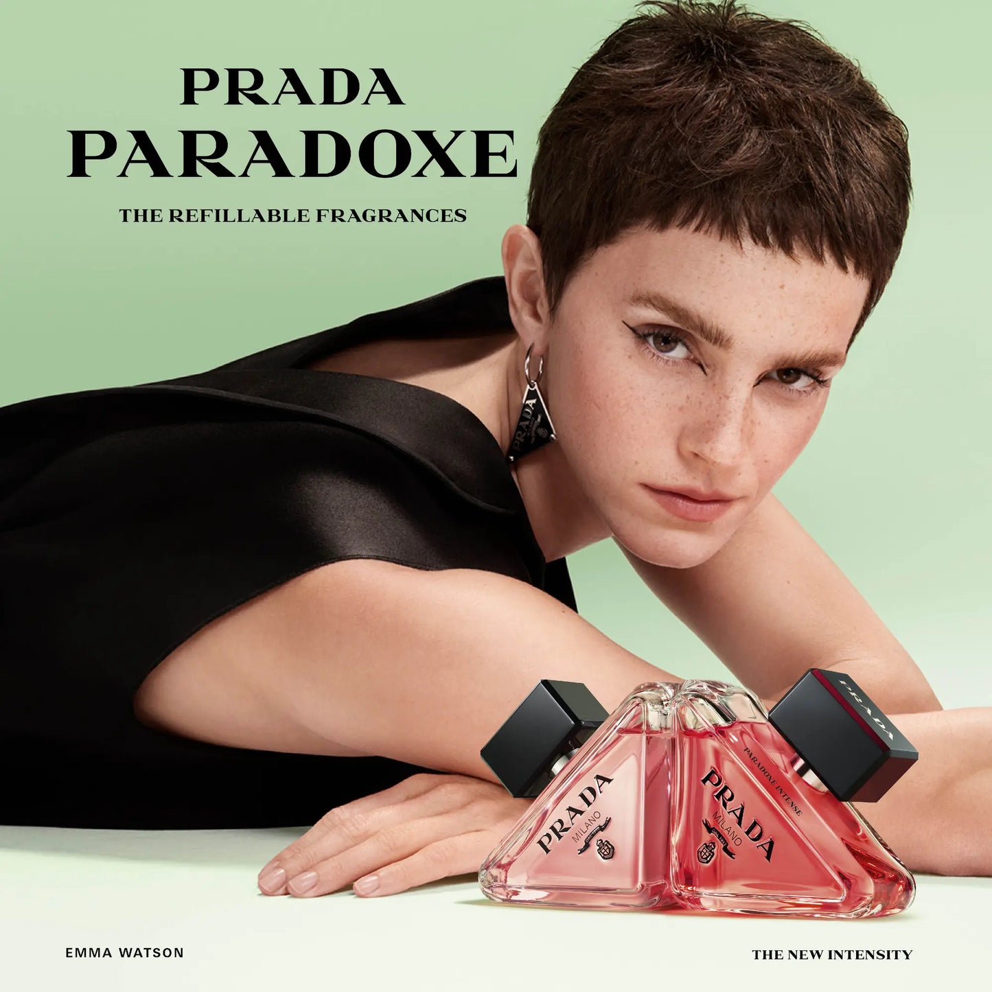 Prada Paradoxe perfume bottle with a model posing on a light green background