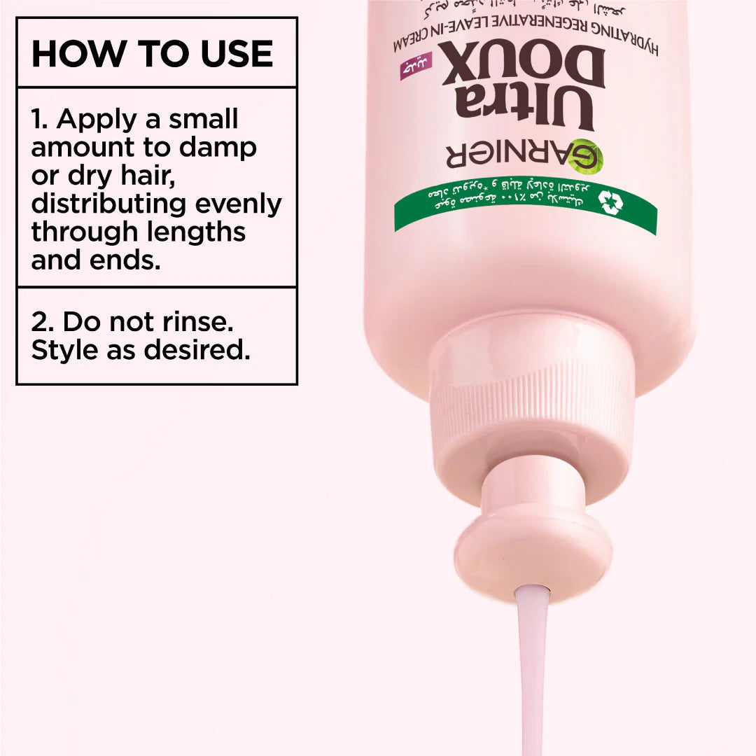 Pink bottle of Garnier Ultra Doux hair product with usage instructions on a white background