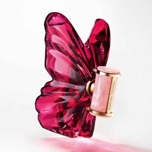 Pink butterfly-shaped perfume bottle Carolina Herrera La Bomba with gold cap on a white background