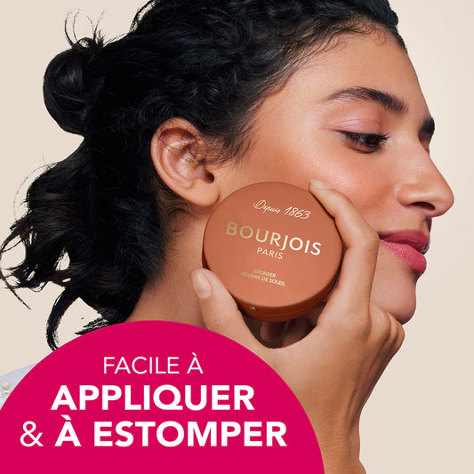 Woman applying Bourjois makeup compact with a pink label in the corner