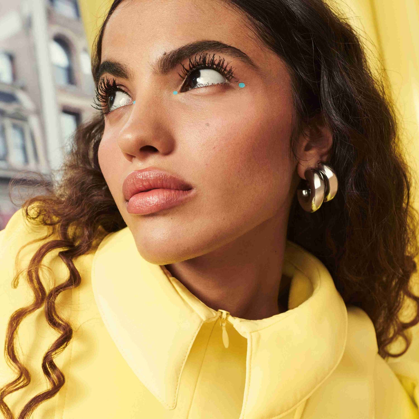 Woman wearing a yellow outfit with a close-up of her face.
