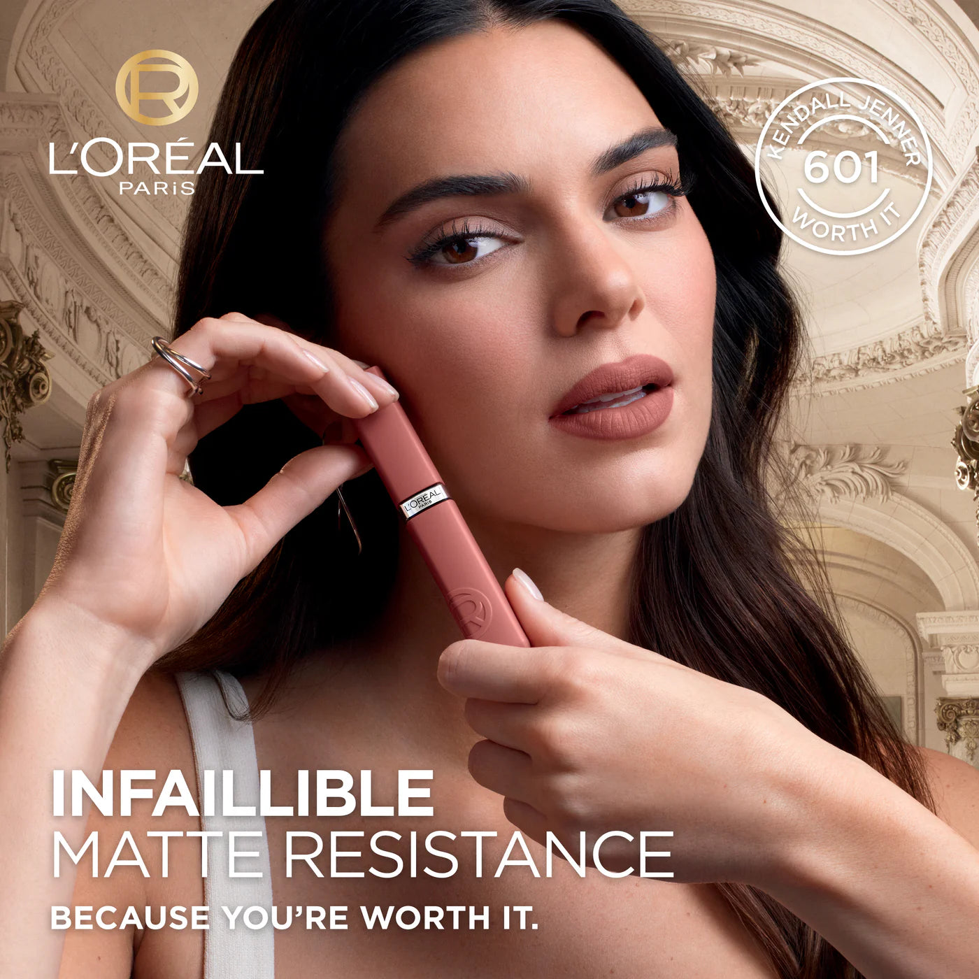 L'Oreal Paris makeup product with a woman applying it, set against an elegant interior background.
