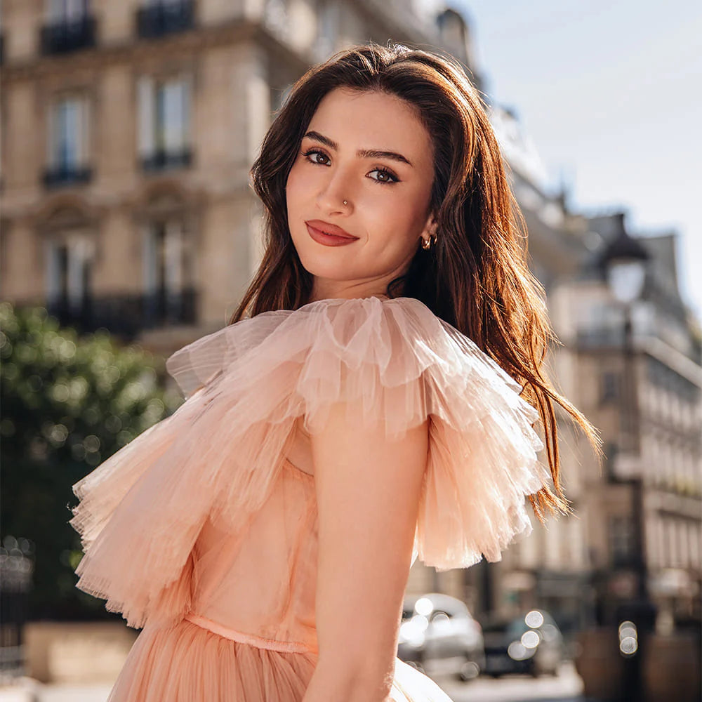 Woman in a peach dress standing in an urban setting