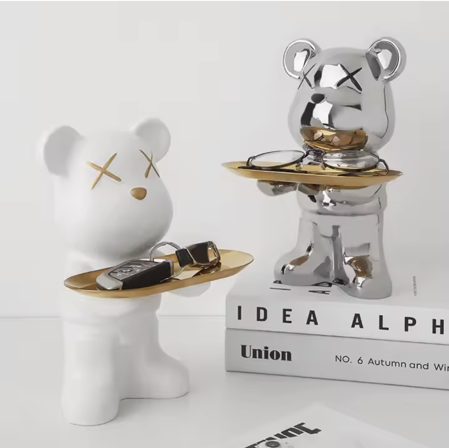 Two decorative bear figurines with gold accents on a white surface.