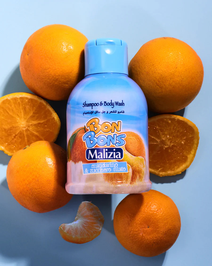 Bon Bons Malizia shampoo and body wash bottle surrounded by oranges on a blue background