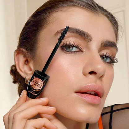 Woman applying Bourjois Bond Force mascara with a brush to her eyelashes, holding a mascara tube close to her face.