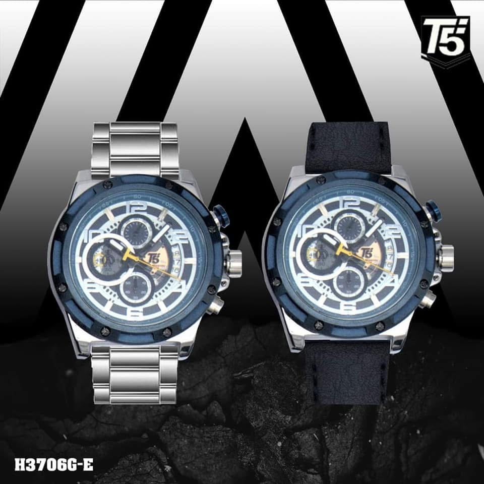 Two watches with blue faces and silver and black straps on a black and white striped background.