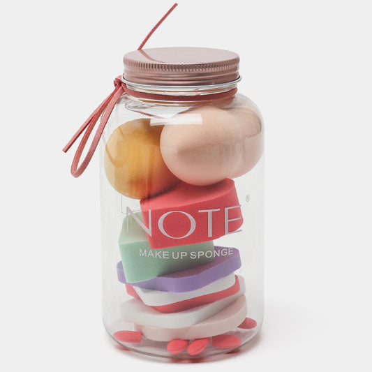 Makeup sponges in a clear jar labeled 'Note' on a white background
