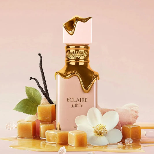 Eclaire perfume bottle with vanilla beans and flowers on a pink background