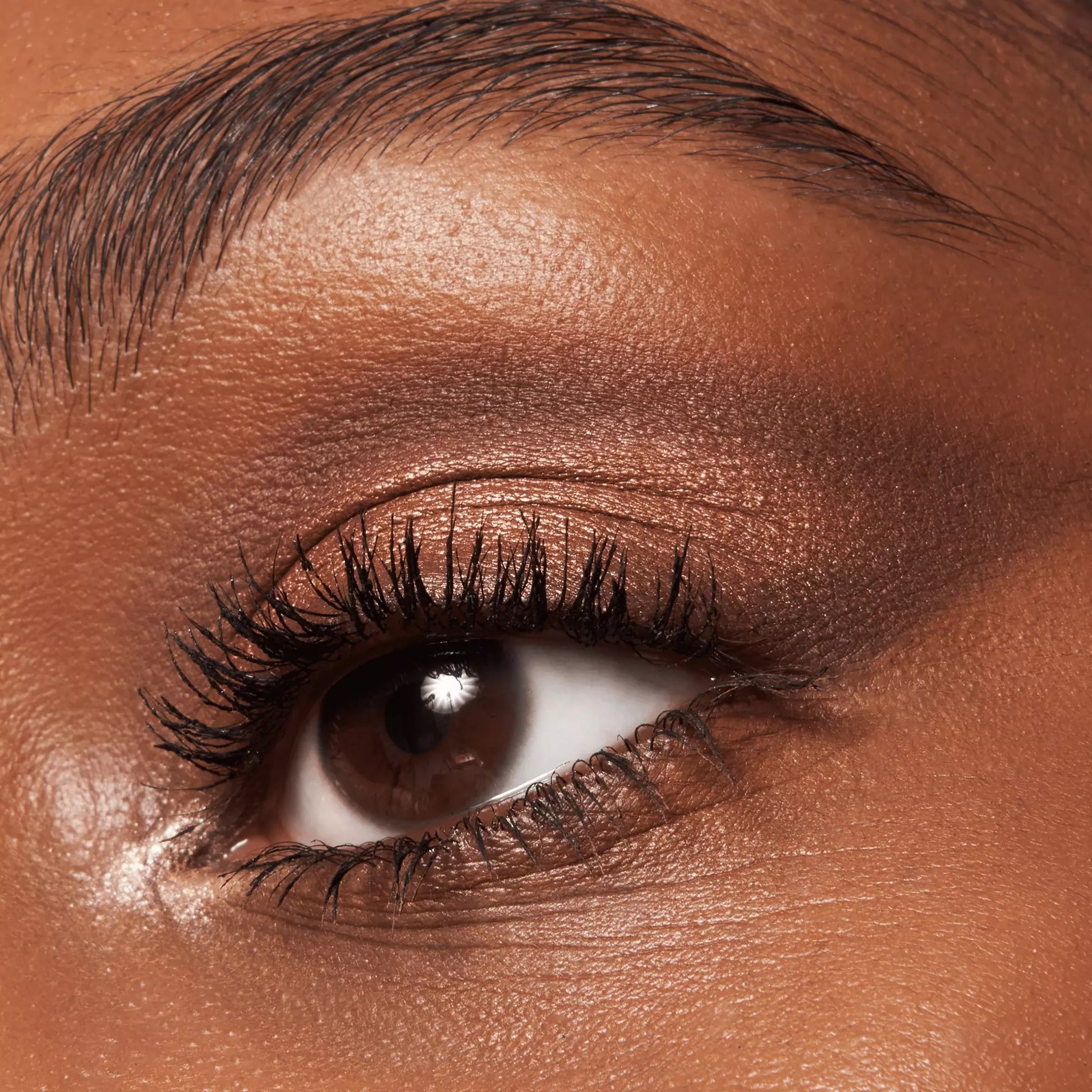 Close-up of a person's eye with bronze eyeshadow and eyeliner.