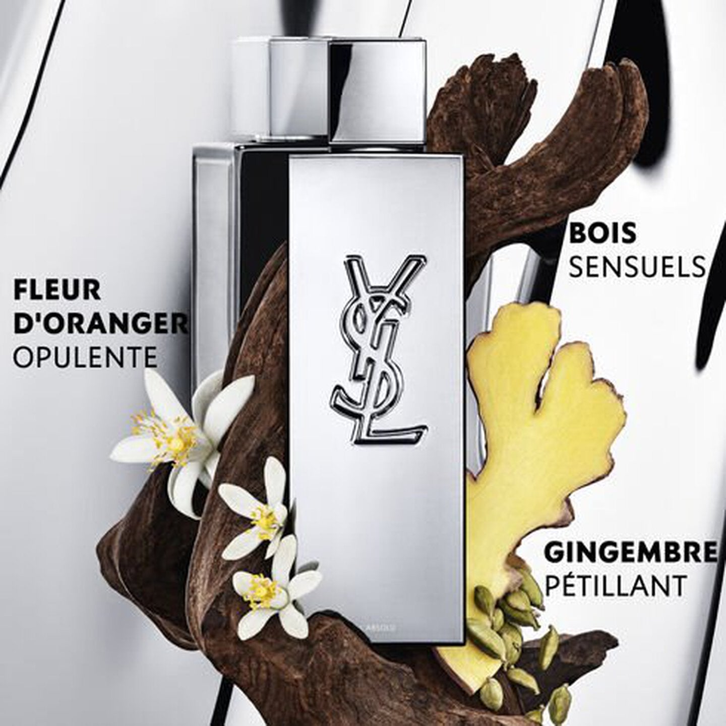 YSL perfume bottle with floral and wood elements on a white background