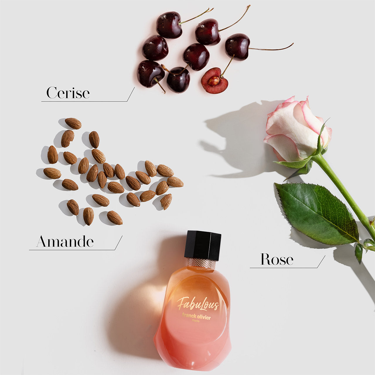 Perfume bottle labeled 'Fabulous' with cherries, almonds, and a rose on a light background